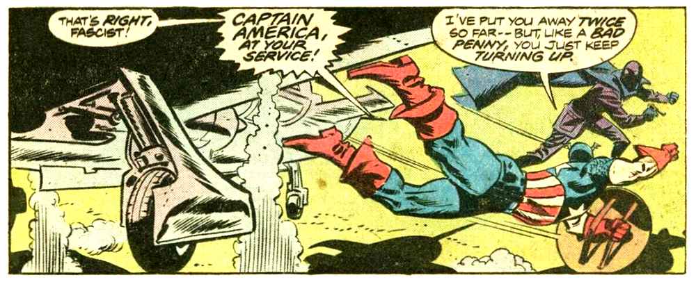 A panel from this issue showing Captain America jumping out of a plan to attack a man in a dark suit and mask with a dark blue cape. Captain America says “That’s right, fascist! Captain America at your service! I’ve put you away twice so far — but, like a bad penny, you just keep turning up.”